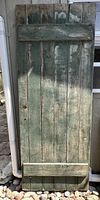 Full view of pine slat door with two horizontal battens and weathered green paint