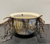 ceramic planter front view showing glaze and wire curls