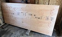 Full view of the uncut plywood sheet leaning against wall