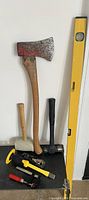 Group of seven hand tools arranged against wall