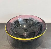 Top view of signed hand-blown glass bowl showing interior color, frit pattern, and yellow rim
