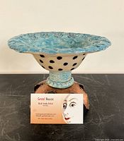Front view of ceramic vessel on copper base with artist business card for scale