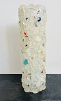 Full view of tall tumbled glass vase standing upright