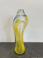 front view of tall handblown vase with yellow and blue streaks