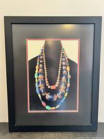Full view of framed photograph showing bead strands