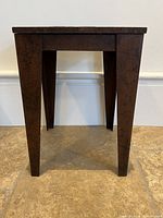 Full side view of steel side table showing tapered legs and square top
