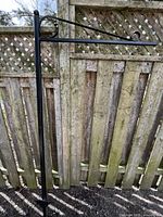 Full view of assembled sign holder against fence