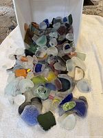 View of container spilling mixed color tumbled glass
