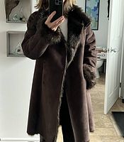 Full front view of coat worn, showing length, color and faux fur trim