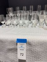 Group of assorted clear glass wine glasses, champagne flutes and highball tumblers displayed on table