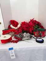All items grouped: poinsettia stems, Santa hat, ribbon spools, pinecones, berry and twig picks