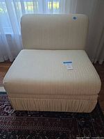 Front view of cream armless slipper chair