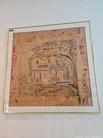 Square framed batik artwork hung on wall, shows full piece in gold frame.