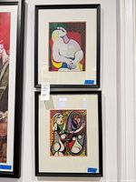 Both framed prints displayed vertically on wall