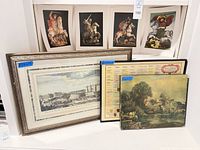 Group shot showing framed architectural print, framed genealogy chart, river landscape board, and five small prints