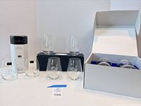 Overall lot showing all glasses and packaging: Dartington box, four swan glasses, two crest glasses on navy box, white box with Mercedes glasses