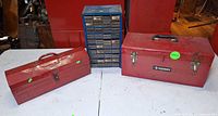 Front view of two red metal toolboxes and blue small-parts cabinet on table