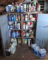 Full cabinet view showing quantity and variety of paints, solvents and jugs