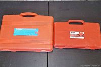 Two red plastic tool cases closed side by side