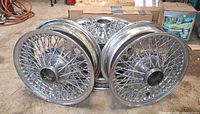 Four chrome wire rims grouped together