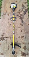 Full view of Ryobi string trimmer laid on plywood