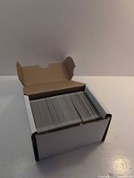 White cardboard card box open showing rows of trading cards