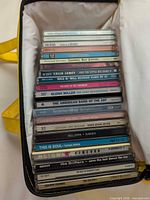 Full view of zippered case opened showing stacked CDs