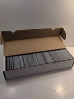 Cardboard 800-count box filled with unsleeved cards, lid open