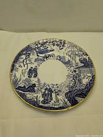 Front view of blue and white plate with gold rim