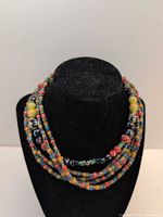 Necklace on display bust showing multistrand design and bead colours