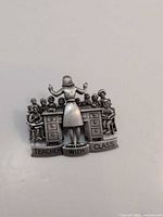 Front view of JJ pewter teacher brooch