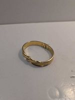 Full view of Monet gold-tone hinged bangle bracelet