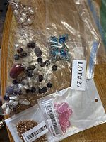 Group of bagged jewellery items including brooch, beads, pendant