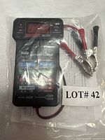 Tester sealed in bag with cables and clamps visible