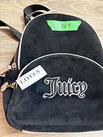 Front view showing Juicy logo, velvet exterior, zipper and dimensions tape
