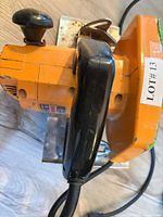 Side view of orange corded circular saw showing handle and housing