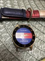 Front view of watch head and detached strap showing dial, bezel, strap colour