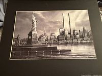 Full view of black-and-white print with Statue of Liberty and Twin Towers, shown in black mat