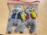 Both gray plush animals in sealed bag