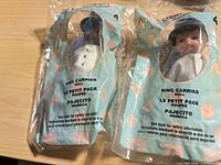 Front view of both sealed Ring Carrier dolls in teal packaging