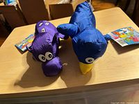 Front view of both satin dog toys with tags attached