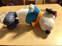 Snoopy plush lying on side showing full outfit and skates