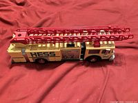 Left side view of Hess yellow fire truck with red ladder