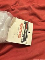 Paper hang tag identifying Truck Toppers clear plastic box