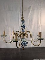 Full view of chandelier with five arms and porcelain accents