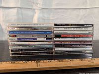 Two side-by-side stacks of the 15 CD spines showing artist and title