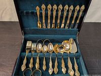 Open case showing full flatware set in teal interior