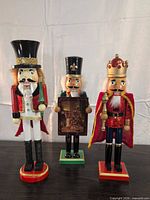 Three nutcrackers standing side by side showing overall condition and appearance