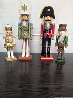 Front view of four wooden nutcrackers showing varied sizes, colors and designs
