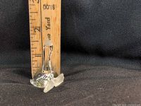 Front view of crystal duck figurine standing beside ruler showing ~2 in. height